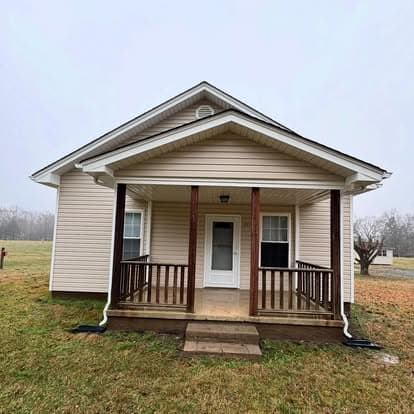 Front view of a charming single-story house with a porch on a foggy day.